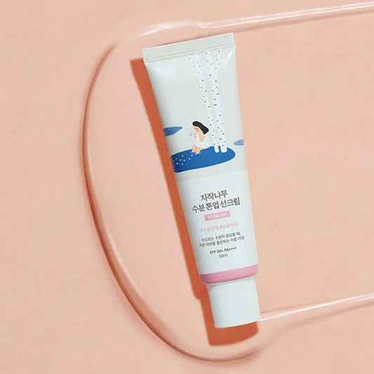 Round Lab Birch Juice Moisturizing Tone Up Sunscreen in a white tube with a pump dispenser, designed to hydrate and brighten skin.